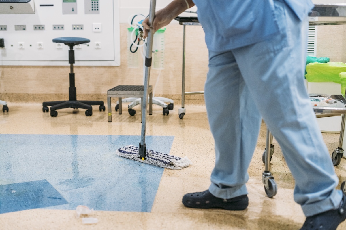 Concept photo of A hospital worker doing cleaning in operation room carpet cleaning